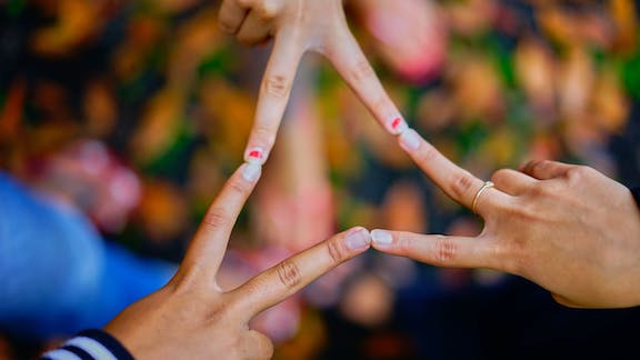 People's fingers forming a triangle