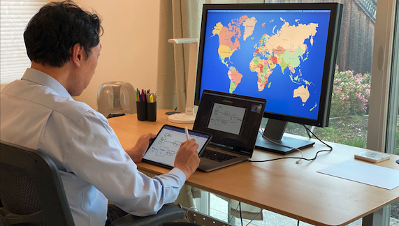 Andrew Ng working on three computers at the same time