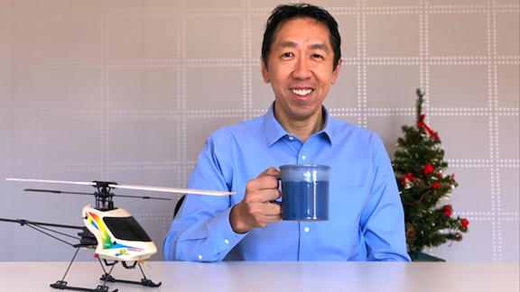 Andrew Ng holding a cup, small christmas tree behind